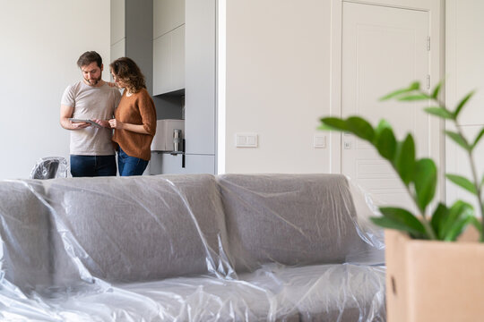 Couple Using Tablet At New Apartment