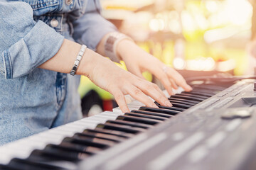 Fototapeta premium Closeup of thumbs up street musician woman playing on mobile piano