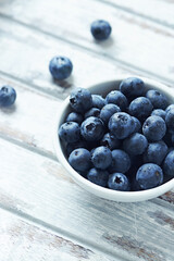 Bilberries on bright wooden background. Close up. Copy space. 