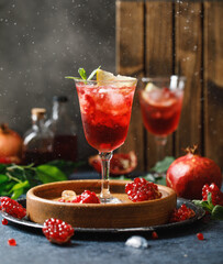 Pomegranate refreshing summer cocktail on dark background. Summer cocktail