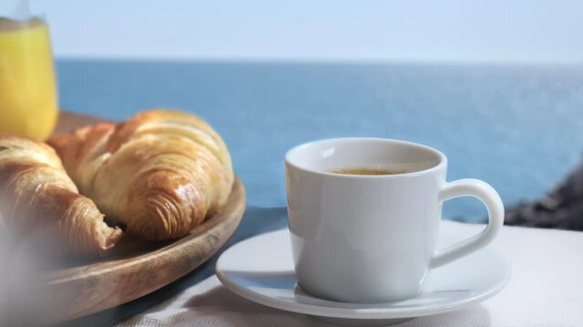 Vacation breakfast luxury restaurant or hotel sea view. Romantic honeymoon travel holiday. Outdoor breakfast with coffee, croissants and fresh orange juice. Beautiful morning concept.