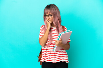 Young student woman with pink hair isolated on blue background having doubts
