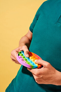 man playing with a rainbow destressing toy