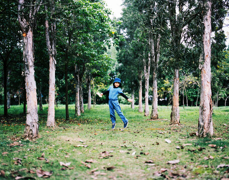 Cute Asian little girl playing in the woods outdoor. Shooting 120 film camera