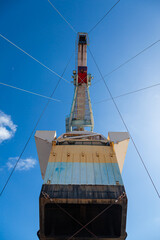 The boom of a large industrial floating crane is secured with cables for transportation, bottom view.