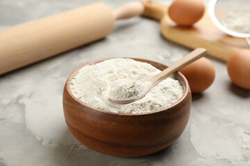 Bowl of flour with spoon on light grey table