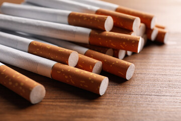 Pile of cigarettes on wooden table, closeup