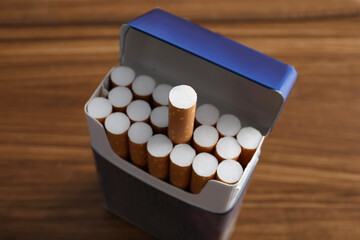 Pack of cigarettes on wooden table, closeup
