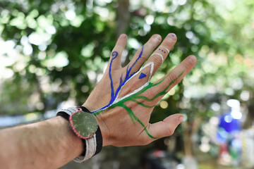 Human hand with painted tree figures, creative activity concept