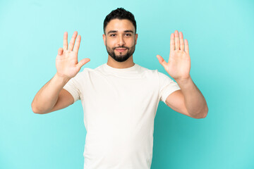 Young arab man isolated on blue background counting nine with fingers