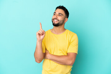 Fototapeta premium Young arab man isolated on blue background pointing up a great idea