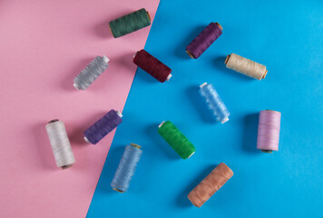 Colorful threads  isolated on pink and blue backgrounds.