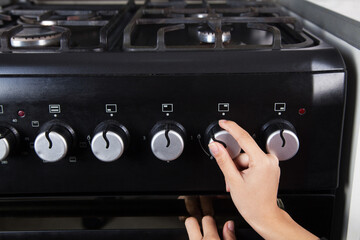 Gas stove and woman in the kitchen.