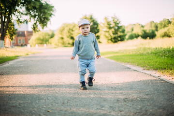 Fototapeta premium Cute and handsome baby boy 1-2 years old exploring nature in summer, having fun