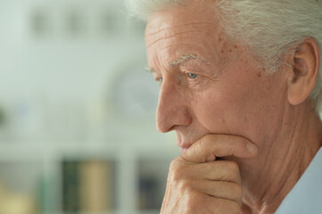 Close up portrait of thoughtful senior man at home