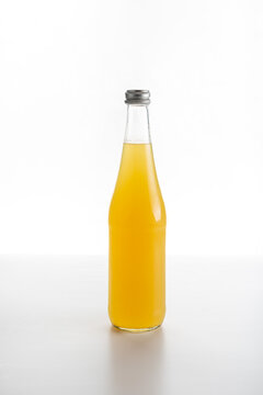glass bottle of citrus lemonade on a white background
