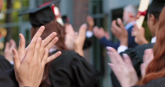 Great moment. Full length view of the teacher giving diploma to the student girl wearing graduation gown and hat. Girl and her group mates rejoicing and celebrating