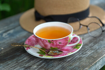 Summer still life with a cup of tea, a book and a bouquet of cornflowers.