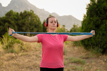 Mujer con auriculares haciendo ejercicio fisico en el parque