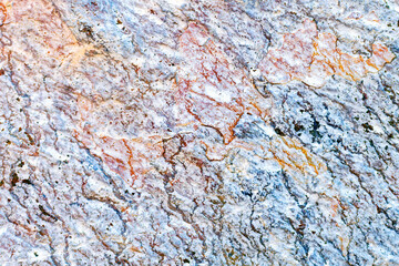 Uneven stone texture background, closeup. Natural colorful hard rock surface