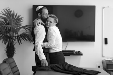 Black and white image of Jewish man in yarmulke gently holding and cuddle together of the woman in...