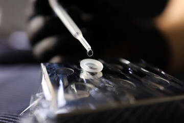 tattoo artist pipette adds a drop of water to stir the pigment