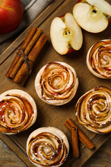 Freshly baked apple roses on wooden table, flat lay. Beautiful dessert