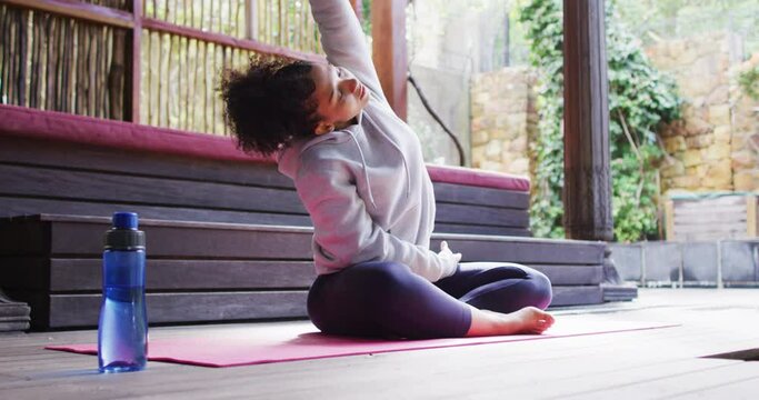 African american woman performing stretching exercise at vacation home
