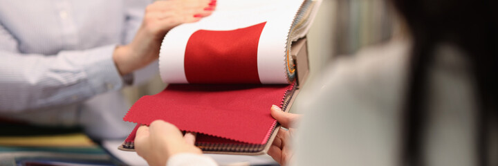 Seller shows visitor a red fabric in salon