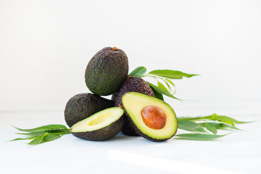 Mature ripe avocado haas with leaves on a white background