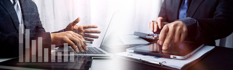 Business people use tablets and hold credit cards as an online shopping concept With a calculator and a book placed on the table