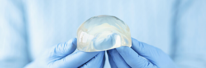 Silicone breast implant in hands of doctor