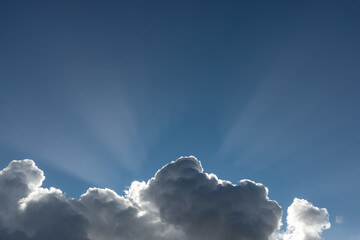 Nubes en el cielo azul con rayos de sol.
