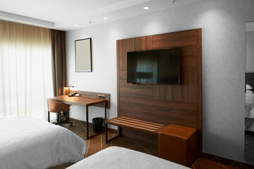 Modern hotel bedroom with a TV and work desk
