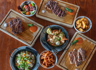 Variety of grilled steak meat dishes, squid dish, fresh vegetables and various ingredients. View from above.Top view. Flat 