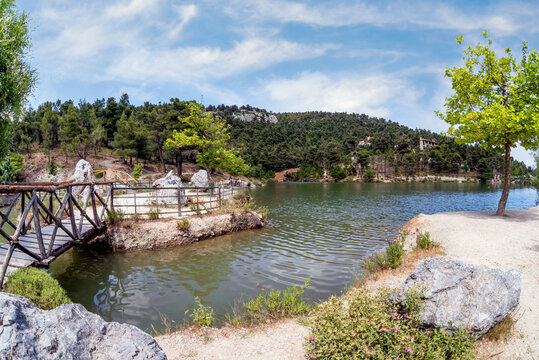 Beletsi Lake panoramic view. The lake is located at an altitude of 600 meters on the eastern slopes of Parnes mount. Athens, Attica, Greece. Sunny day, cloudy blue sky