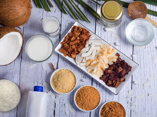 coconut products on wooden table background. Coconut oil, coconut milk and shredded coconut