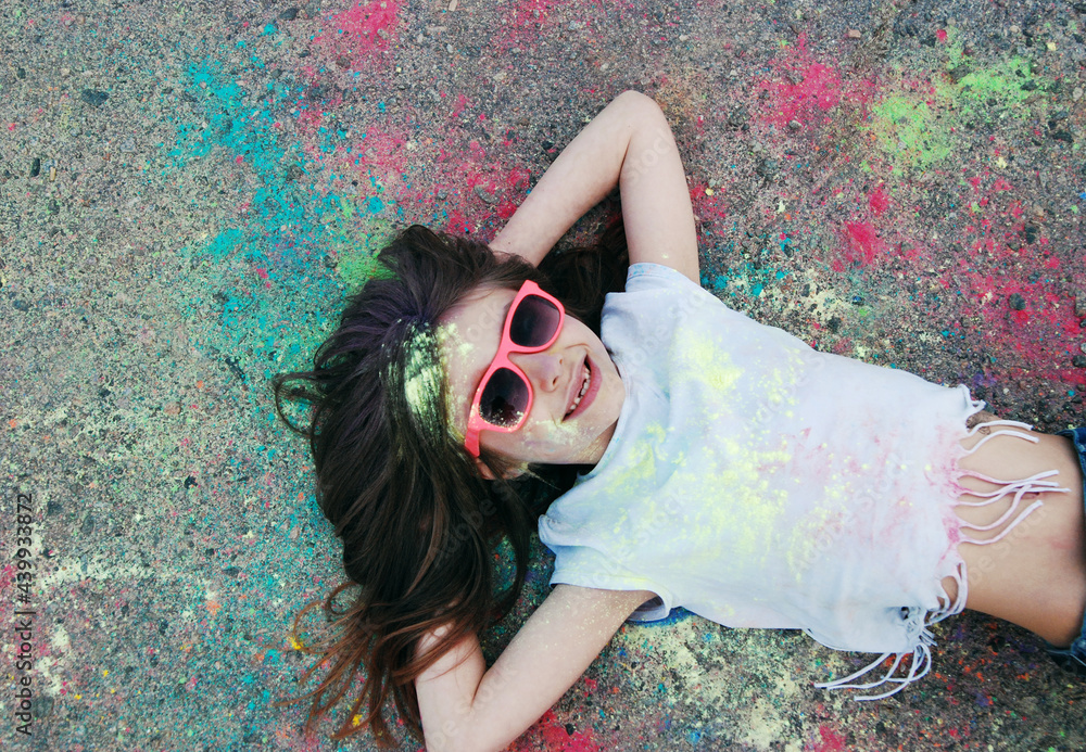 Wall mural Little girl has fun with paints on Holi festival