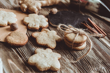 Close up of homemade ginger cookies, cinnamon, ginger on a wooden table. Copy space. Retro toned image, flat lay