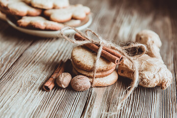 Close up of homemade ginger cookies, cinnamon, ginger on a wooden table. Copy space. Retro toned image, flat lay