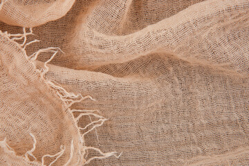 Gauze tablecloth texture background. Beige gauze fabric top view with copy space.
