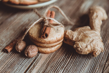 Close up of homemade ginger cookies, cinnamon, ginger on a wooden table. Copy space. Retro toned image, flat lay