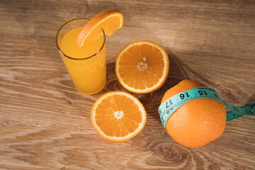 orange on the table, measuring tape and orange juice © Fantastic