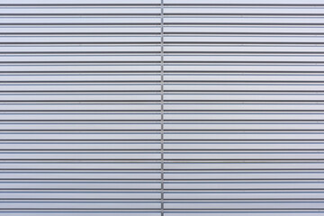 Texture of a silver corrugated sheet metal aluminum facade.