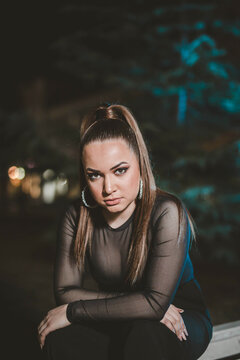 Portrait Of A Confident Caucasian Woman Wearing A Sheer Shirt Outdoors At Night