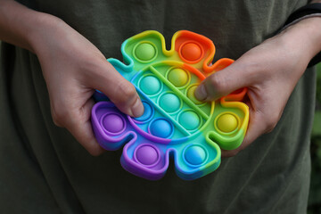 Girl play in sensory anti stress Pop It in flower shape toy. Close up.