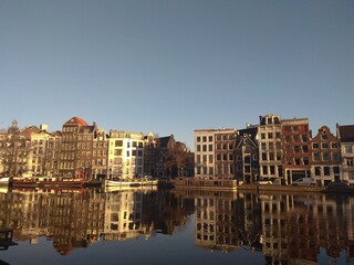 Fototapeta na wymiar Amsterdam houses urban city view. Building near the water. Amsterdam houses bright daytime photos