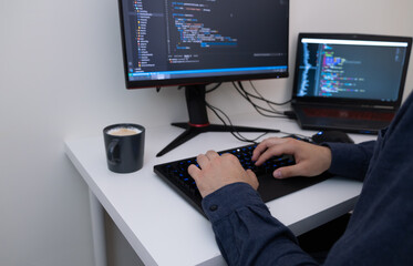 Male programmer working from home. Male hands are typing the code. Technology and homework concept