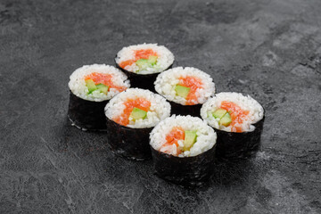 Sake maki Japanese roll with Salmon and avocado on stone. Saki sushi-roll