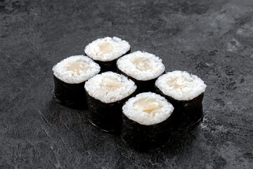 Sake maki Japanese roll with sea Scallop on stone. Saki sushi-roll